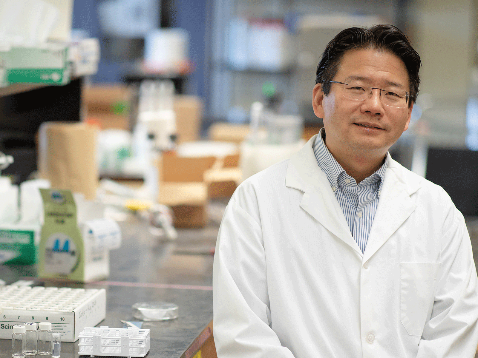 Professor Gu sitting in a laboratory.