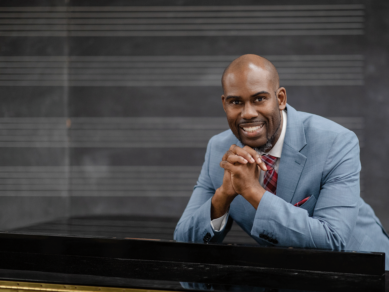 Headshot of Prossor Darren Hamilton sitting at a piano.