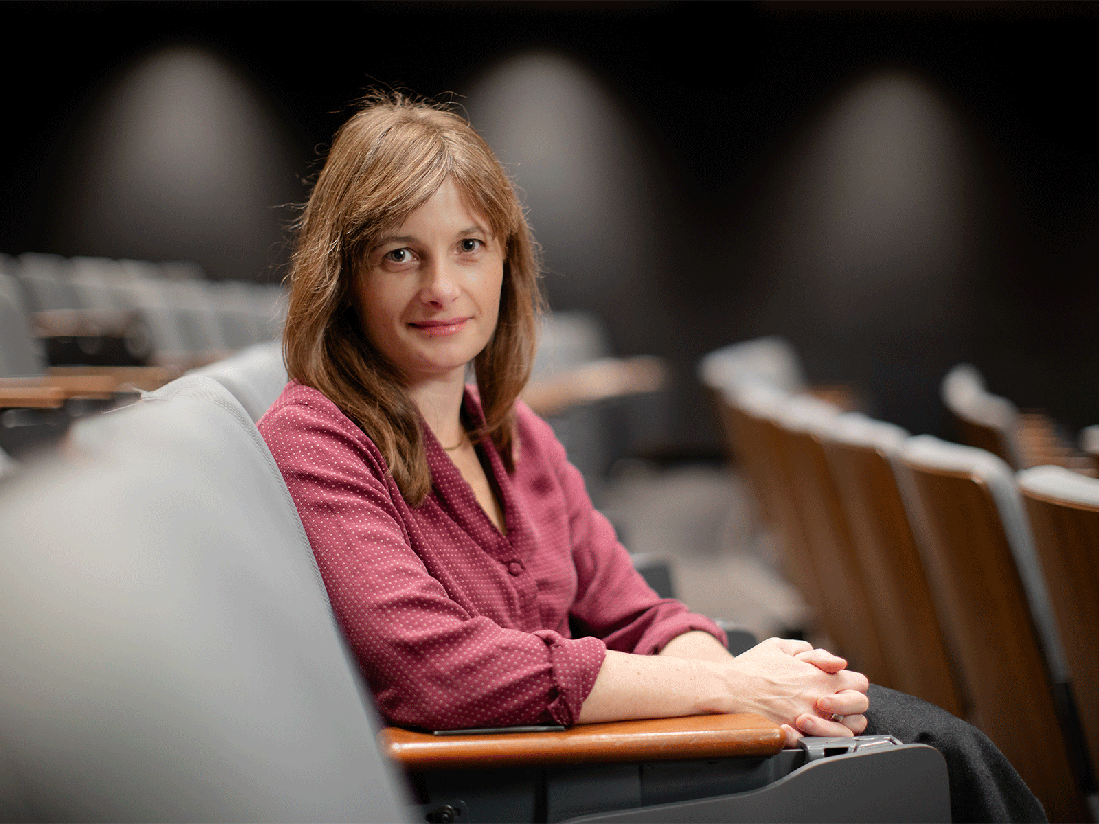 Headshot of Professor Brett Story in a the audiance section of an empty theatre.